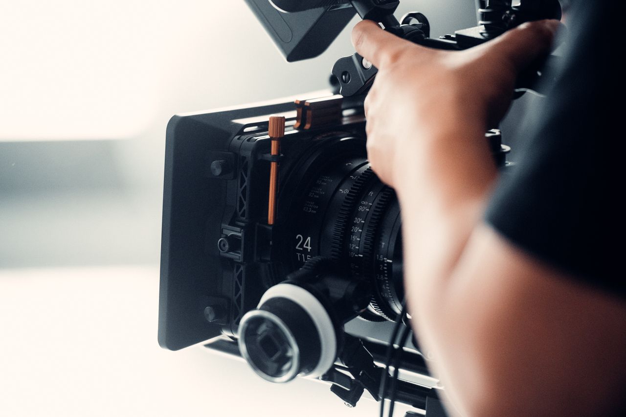 Hands operating a professional cinema camera on set